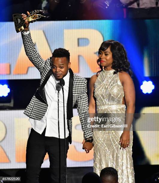 Musician Travis Greene accepts the award for "Male Vocalist of the Year" as Jacqueline Gyamfi Greene stands onstage during the 32nd annual Stellar...