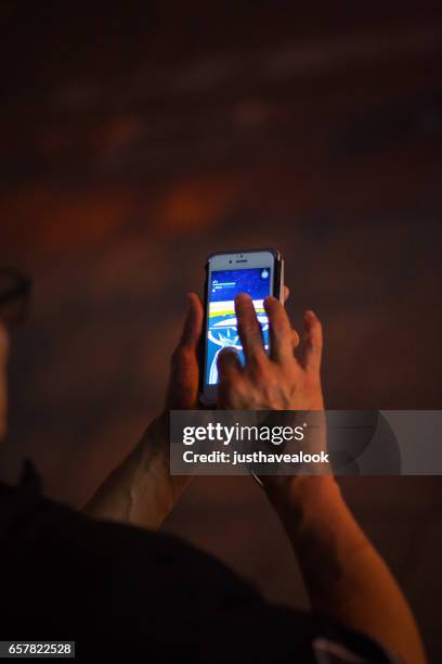 adult thai man play pokemon go - pokemon go stock pictures, royalty-free photos & images