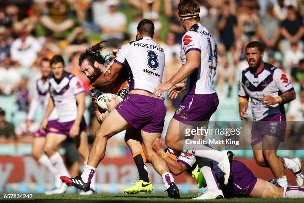 Aaron Woods of the Tigers is tackled during the round four NRL match between the Wests Tigers and the Melbourne Storm at Leichhardt Oval on March 26,...