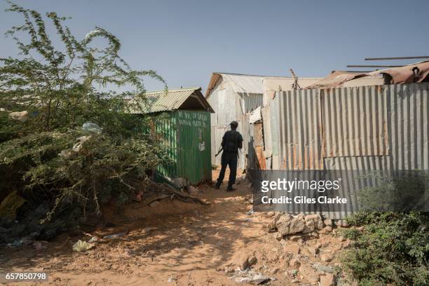 March 6, 2017: A local security officer patrols an internally displaced persons camp in central Mogadishu. Somalia is in the grip of an intense...