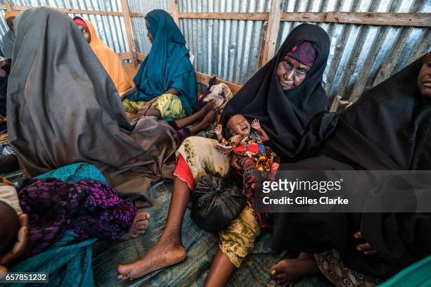 Grandmother holds her badly malnourished grandchild at a World Food Program food center in central Mogadishu. Somalia is in the grip of an intense...