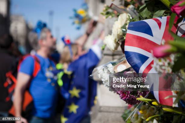 Pro-European protesters place flowers on the gates of Westminster in respect of the victims of the Westminster Attacks during the 'Unite For Europe'...