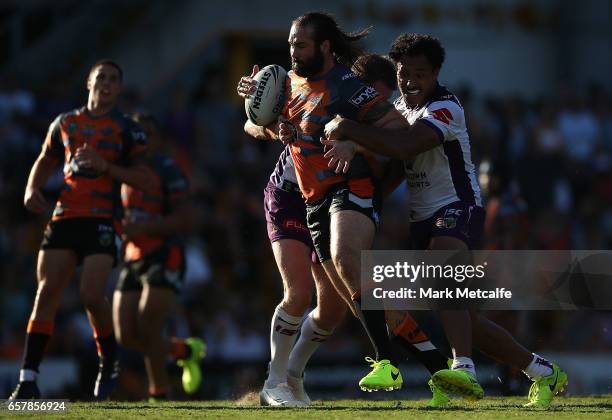 Aaron Woods of the Tigers is tackled during the round four NRL match between the Wests Tigers and the Melbourne Storm at Leichhardt Oval on March 26,...