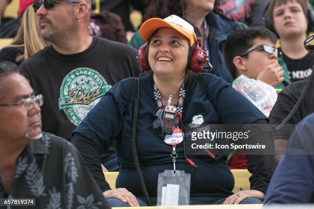 Fan smiles as her driver makes a move during the Xfinity Series 19th Annual Service King 300 at Auto Club Speedway in Fontana, California on March...