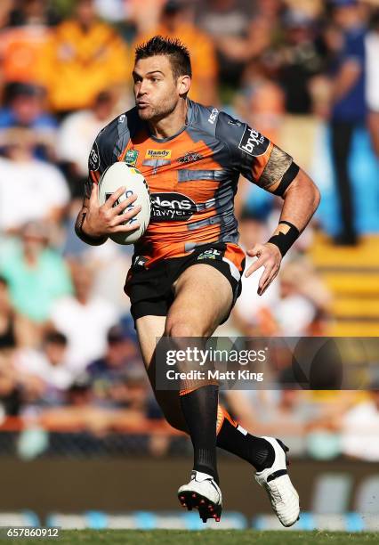 Tim Grant of the Tigers runs with the ball during the round four NRL match between the Wests Tigers and the Melbourne Storm at Leichhardt Oval on...