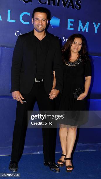 Indian Bollywood actor Rohit Roy with his wife Manasi Joshi pose as they attend a "Chivas 18 Alchemy" promotional event in Mumbai on March 25, 2017....