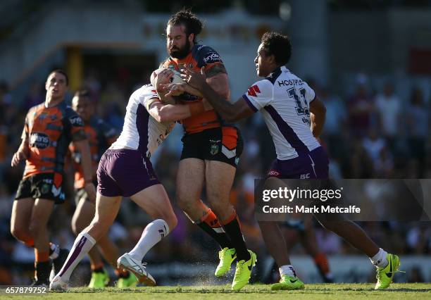 Aaron Woods of the Tigers is tackled during the round four NRL match between the Wests Tigers and the Melbourne Storm at Leichhardt Oval on March 26,...