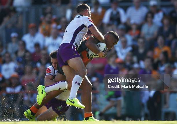 Michael Chee-Kam of the Tigers is tackled during the round four NRL match between the Wests Tigers and the Melbourne Storm at Leichhardt Oval on...