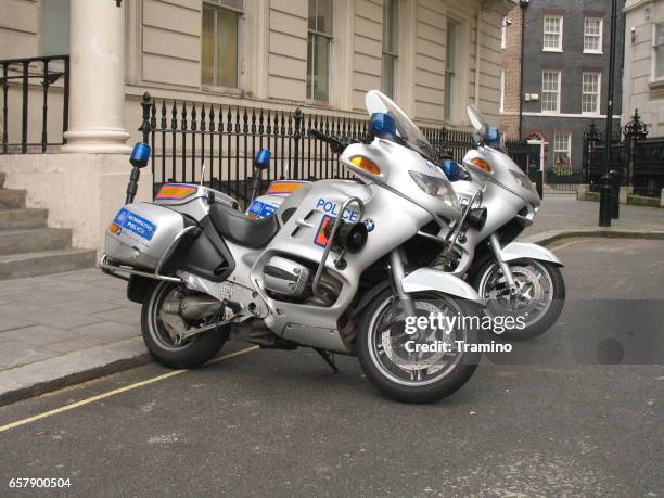 polizei-motorräder parken auf der straße - police motorbike stock-fotos und bilder