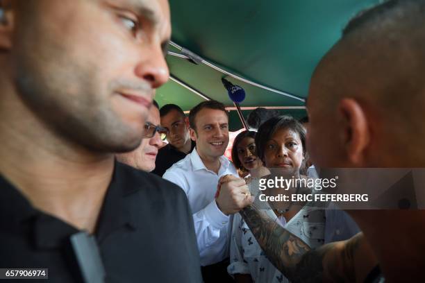 French presidential election candidate for the En Marche ! movement Emmanuel Macron shakes hands with a man during his visit at Le Chaudron market in...