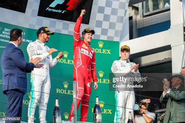 Race winner Sebastian Vettel of Germany, driving for Scuderia Ferrari, celebrates on the podium as 2nd place winner Lewis Hamilton of the United...