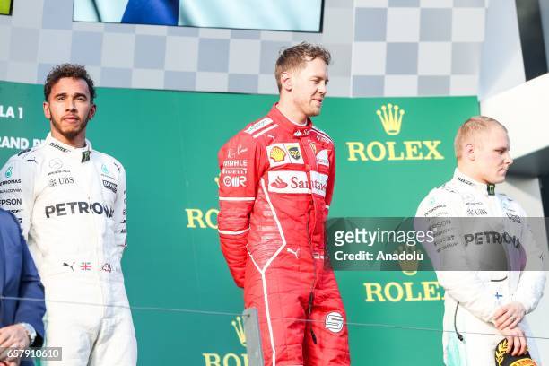 Race winner Sebastian Vettel of Germany, driving for Scuderia Ferrari, 2nd place winner Lewis Hamilton of the United Kingdom, driving for Mercedes...