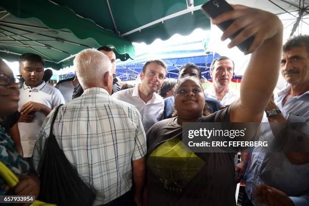 French presidential election candidate for the En Marche! movement Emmanuel Macron takes a selfie with a woman during a visit to the Le Chaudron...