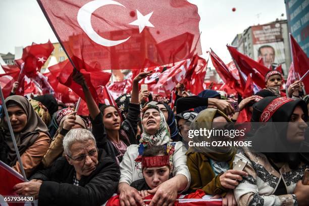 People wave national flags and cheer during a rally in support of the Turkish President on March 26, 2017 in Istanbul. Turkish President Recep Tayyip...