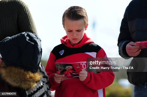 Young Bristol City fan reads a programme during the SSE FA Women's Cup Sixth Round match between Bristol City Women and Manchester City Women at the...
