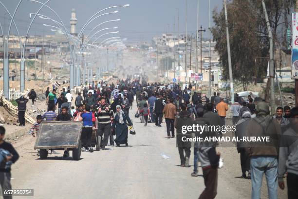 Iraqis fleeing the fighting against Islamic State group are seen in Mosul on March 26, 2017 as an ongoing operation against the jihadists continues....