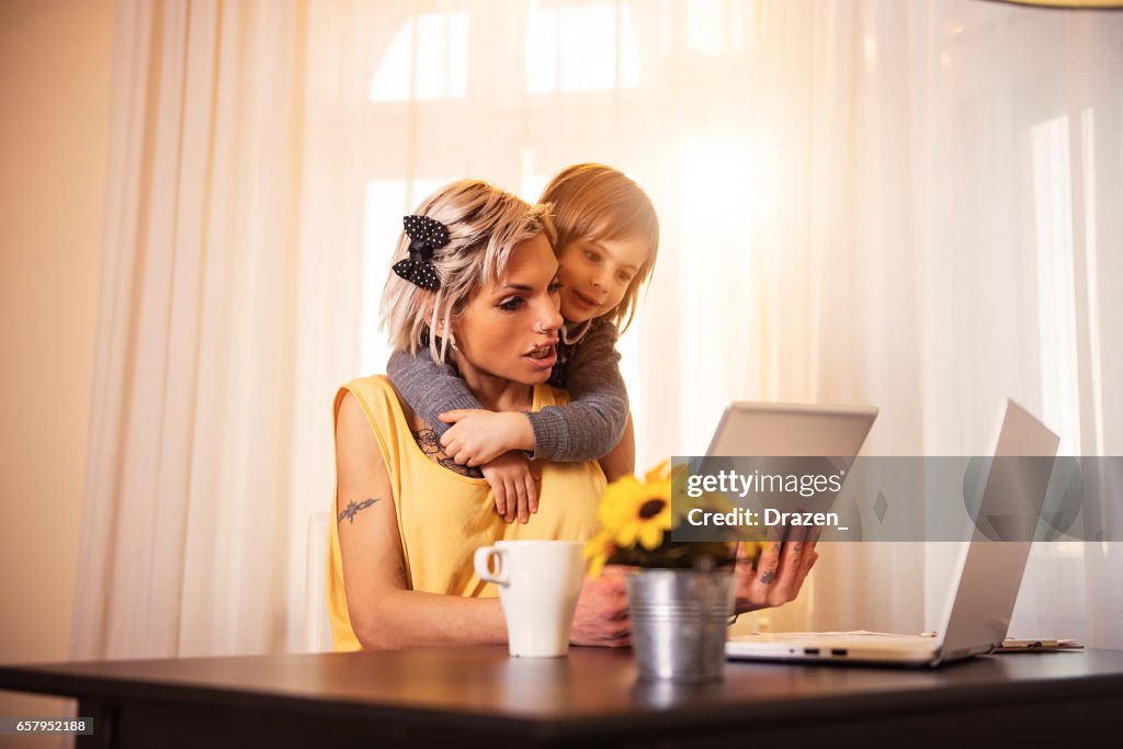 Single mom with tattoos at home, spending time with her young daughter