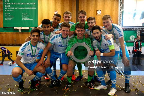 The team of Schalke poses the winning trophy of the B Juniors German Indoor Football Championship at Sporthalle West on March 26, 2017 in Gevelsberg,...