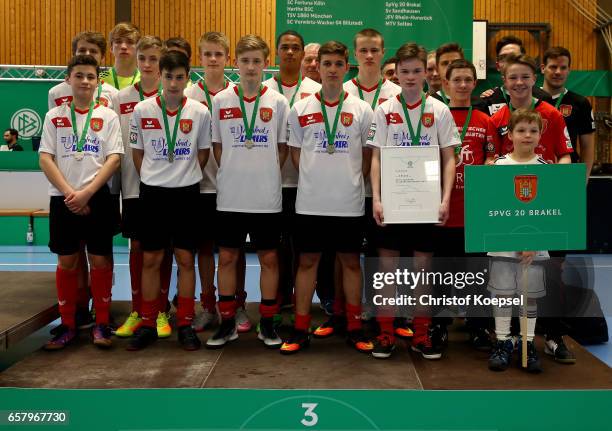 The team of SpVg Brakel poses on the podium after winning the third place of during the C Juniors German Indoor Football Championship at Sporthalle...