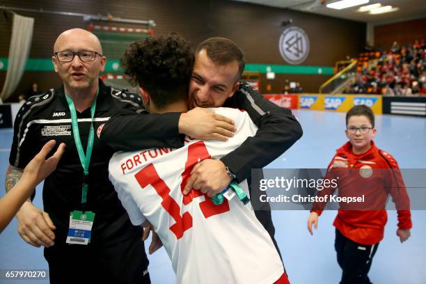 Head coach Ismail Oeztuerk of SC Fortuna Koeln embraces Batuhan Bayrak of SC Fortuna Koeln after winning the final match between SV Sandhausen and...