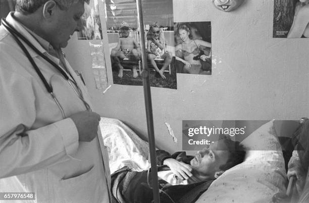 This picture taken in March 2005 shows a doctor examining a HIV/AIDS patient during a round at Odessa hospital. With an estimated 1.4 percent...