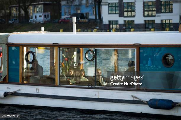 People are pictured on board of a boat sailing the Spree in the district of Friedrichshain-Kreuzberg in Berlin, Germany on March 25, 2017.