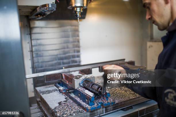 Metal machining industry. Worker operating cnc milling machine