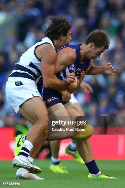 Nakia Cockatoo of the Cats tackles Lee Spurr of the Dockers during the round one AFL match between the Fremantle Dockers and the Geelong Cats at...