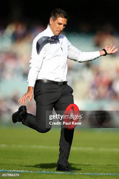 Fox Sports commentator Matthew Pavllich attempts to kick the ball from the 50 meter line for charity before the round one AFL match between the...
