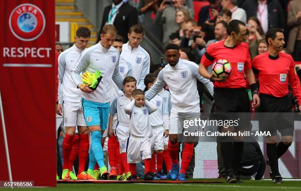 Mascot Bradley Lowery covers his ears as he walks out with Jermain Defoe of England during the FIFA 2018 World Cup Qualifier between England and...