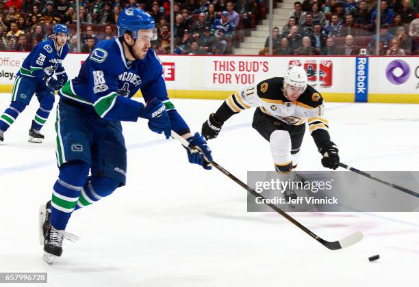 Nikita Tryamkin of the Vancouver Canucks skates by Jimmy Hayes of the Boston Bruins during their NHL game at Rogers Arena March 13, 2017 in...