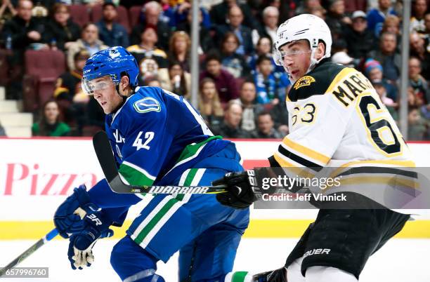 Brad Marchand of the Boston Bruins and Drew Shore of the Vancouver Canucks skate up ice during their NHL game at Rogers Arena March 13, 2017 in...