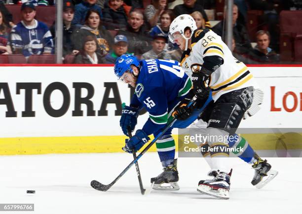 Michael Chaput of the Vancouver Canucks is checked by David Pastrnak of the Boston Bruins during their NHL game at Rogers Arena March 13, 2017 in...