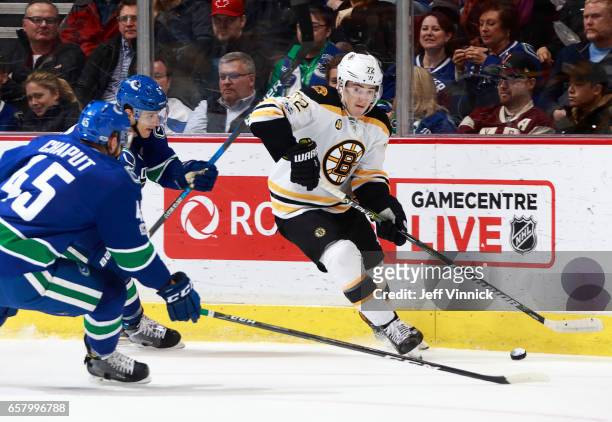 Michael Chaput and Luca Sbisa of the Vancouver Canucks check Frank Vatrano of the Boston Bruins during their NHL game at Rogers Arena March 13, 2017...