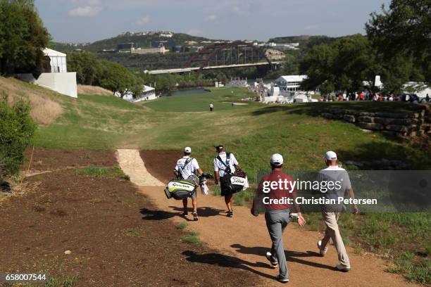 Jon Rahm of Spain and Bill Haas walk on the 12th hole of their match during the semifinals of the World Golf Championships-Dell Technologies Match...