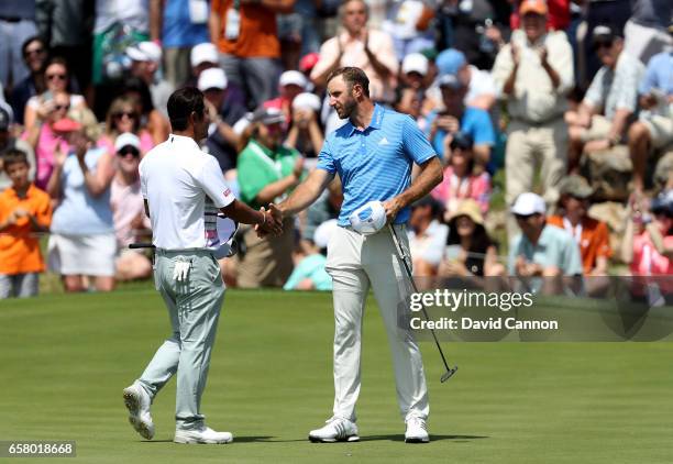 Dustin Johnson of the United States shakes hands with his opponent Hideto Tanihara of Japan on the 18th green Johnson won by 1 hole during the...