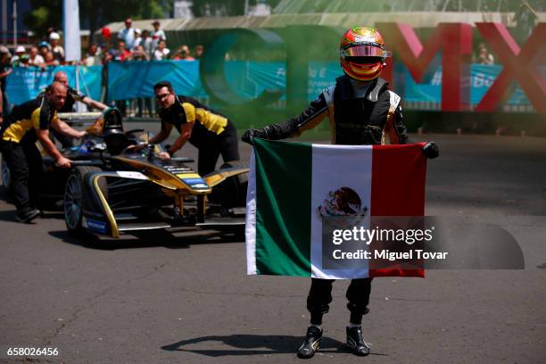 Mexican FE pilot Esteban Gutierrez holds a Mexican flag as he poses for pictures during the Formual E Road Show at Reforma Avenue on March 25, 2017...