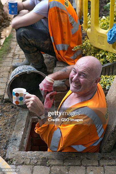 men relax on tea break in sewer - bizarre job stock pictures, royalty-free photos & images