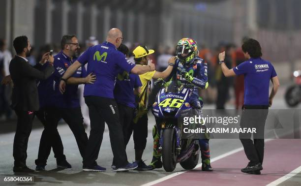Italian racer Valentino Rossi celebrates with his team after Movistar Yamaha MotoGP team won the 2017 Qatar MotoGP at the Losail International...