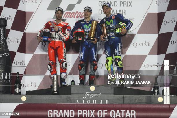 Champion Movistar Yamaha MotoGP's racers Maverick Vinales , teammate Valentino Rossi , and Ducati Team's Italian racer Andrea Dovizioso celebrate on...