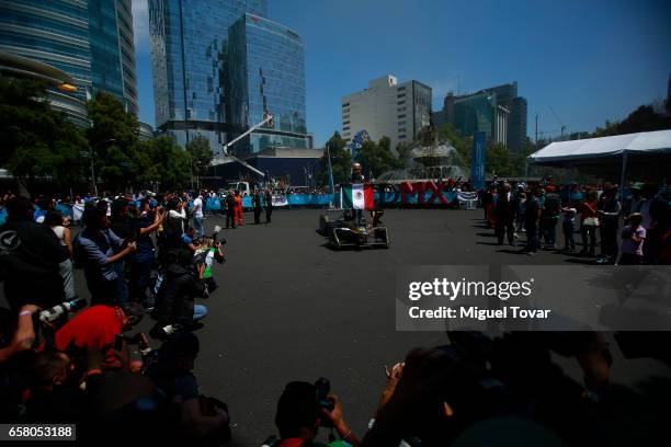 Mexican FE pilot Esteban Gutierrez holds a mexican flag as he poses for pictures during the Formual E Road Show at Reforma Avenue on March 25, 2017...