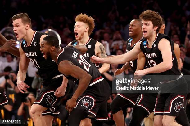 Maik Kotsar and Justin McKie of the South Carolina Gamecocks celebrate with their teammates after defeating the Florida Gators with a score of 77 to...