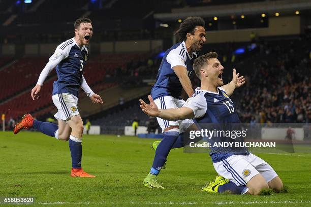 Scotland's striker Chris Martin celebrates scoring the only goal with Scotland's defender Andrew Robertson and Scotland's defender Ikechi Anya during...