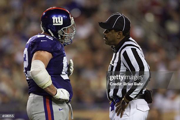 Glenn Parker of the New York Giants talks with umpire Chad Brown after being disappointed about a call during Super Bowl XXXV against the Baltimore...