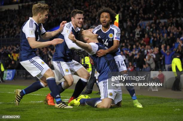 Scotland's striker Chris Martin celebrates with teammates after scoring the only goal of the World Cup 2018 qualification football match between...