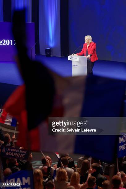 Supporters wave flags as French presidential candidate Marine Le Pen holds a rally meeting at Zenith on March 26, 2017 in Lille, France. The first...