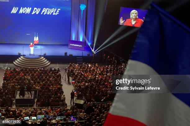 Supporters wave flags as French presidential candidate Marine Le Pen holds a rally meeting at Zenith on March 26, 2017 in Lille, France. The first...