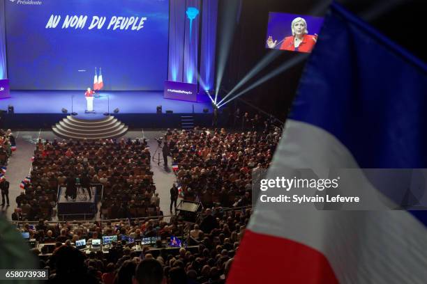 Supporters wave flags as French presidential candidate Marine Le Pen holds a rally meeting at Zenith on March 26, 2017 in Lille, France. The first...