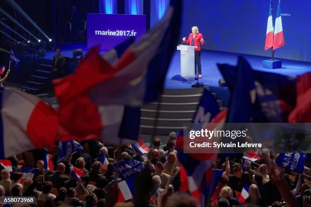 Supporters wave flags as French presidential candidate Marine Le Pen holds a rally meeting at Zenith on March 26, 2017 in Lille, France. The first...