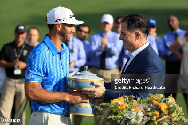 Dustin Johnson is presented with the trophy after winning the World Golf Championships-Dell Technologies Match Play at the Austin Country Club on...